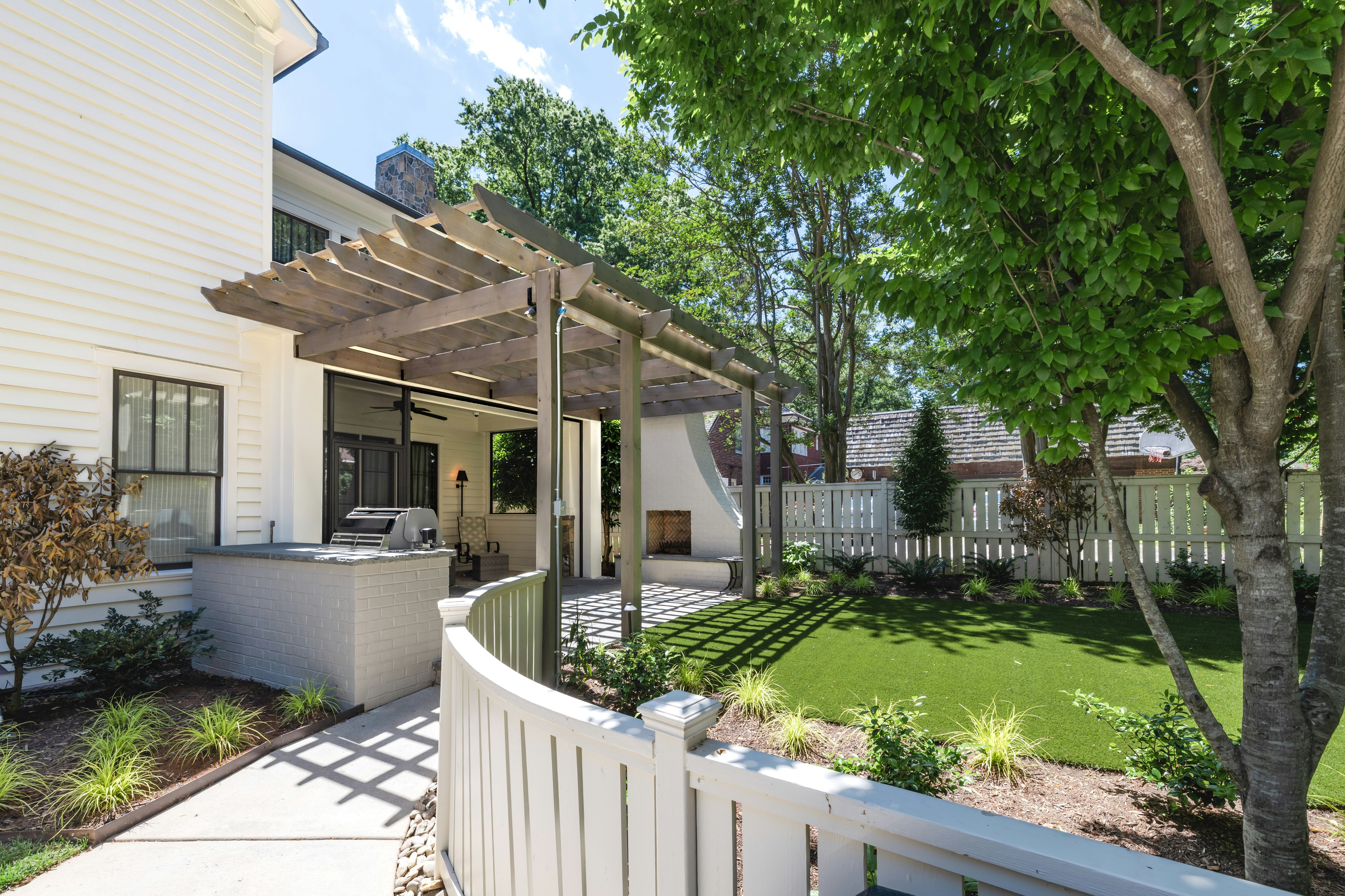 A well-kept backyard with landscaping and a pergola.